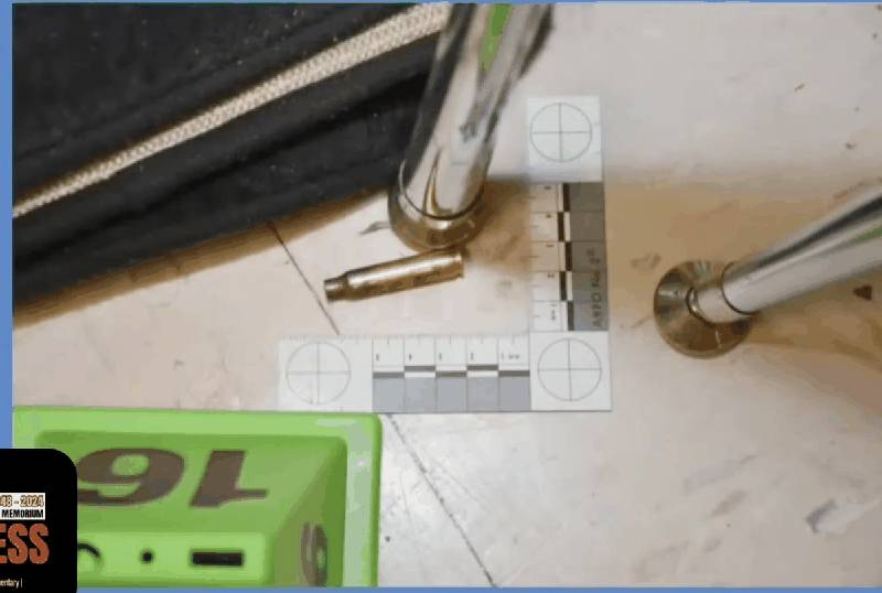 Fired cartridge case on classroom floor with evidence marker