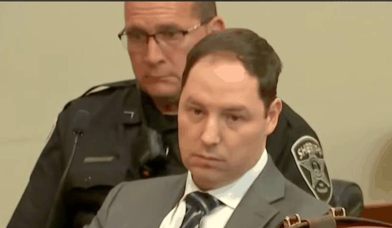 Brendan Banfield at defense table looking down