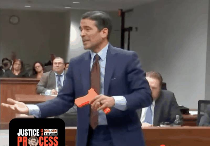 Defense attorney Nico LaHood in courtroom holding training weapon